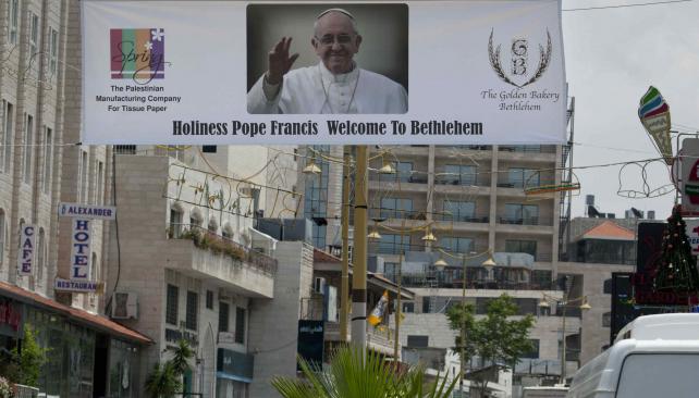 Lo esperan. En Cisjordania, un cartel le da la bienvenida al Pontífice (AP).