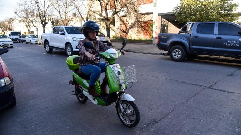 Andando. Gabriela Juárez en su moto eléctrica, por las calles de Villa María. Se queja de que el municipio no las habilite. Pero la usa igual, cada día. (La Voz)
