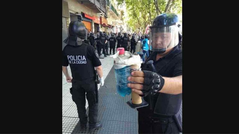 Un policía de la Metropolitana muestra una bomba Molotov.